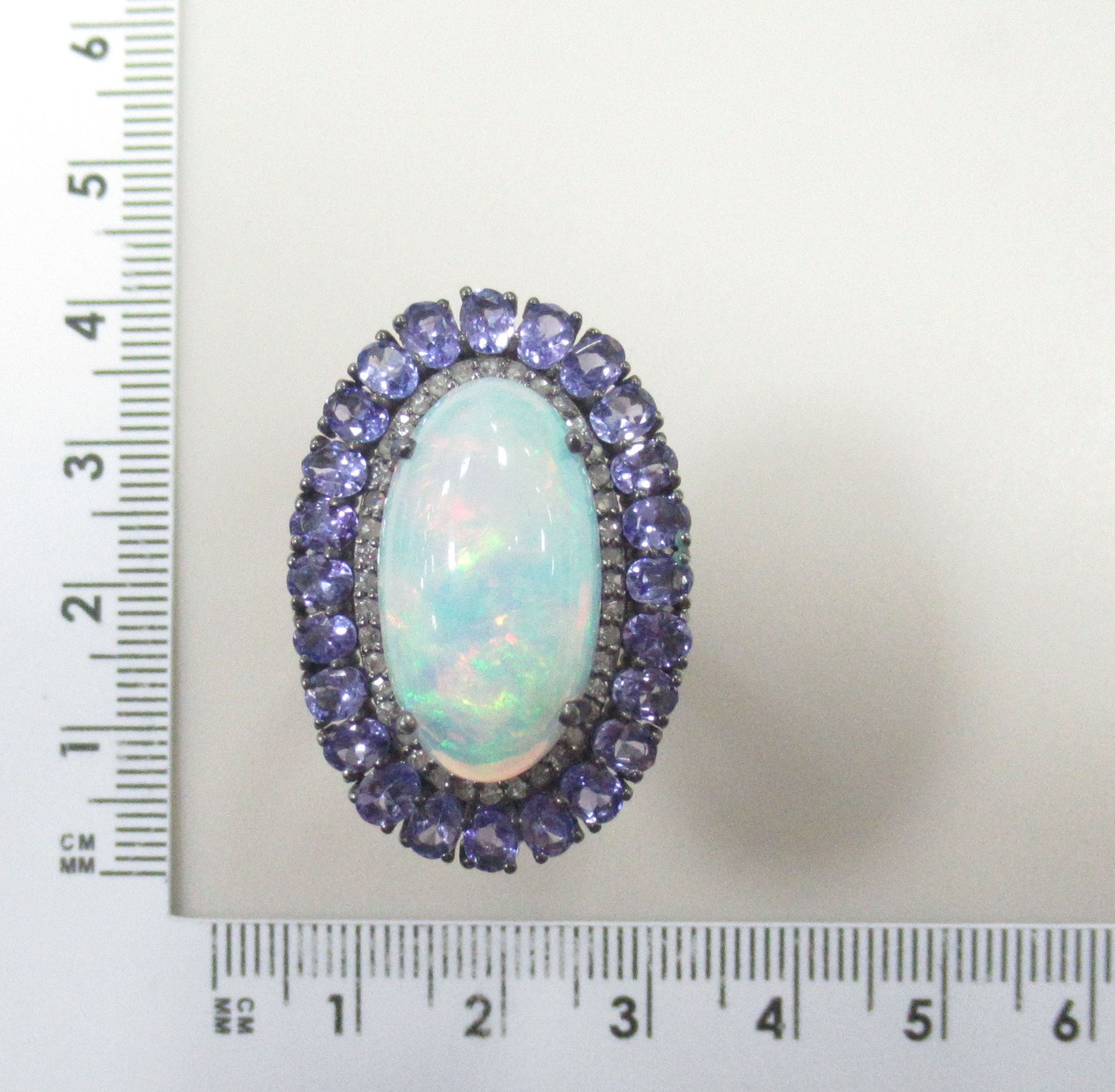 Серебряное кольцо 925 пробы; родий (бел.черн.); вставки 1 Опал бел. 10,5ct (Эфиопия); 24 Танзанит 4,04ct; 40 Бр.Кр-17 0,31ct 3/5;
